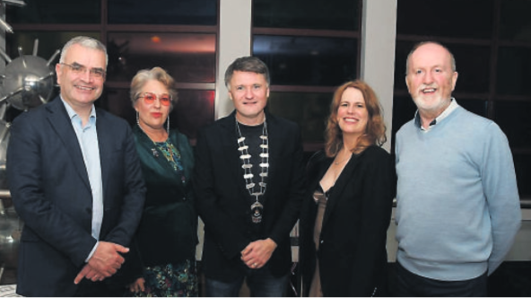 Three men and two women posing at a reception event